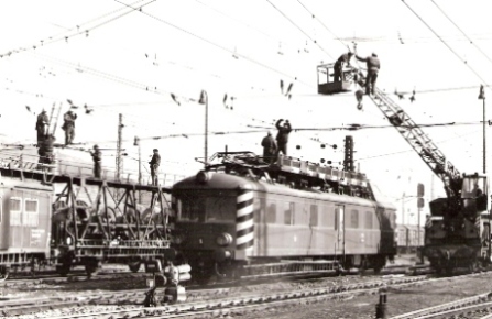  Oprava trakč. vedenia v Žiline (zrejme). Mont. vlak, M 263.0, autožeriav na ploš. vozni, robot. pri práci. Foto: M. Meliška, cca 1980. Text: Pracovníci Elektrizácie železníc Praha a Elektroúseku Vrútky pri práci. 175 x 120 