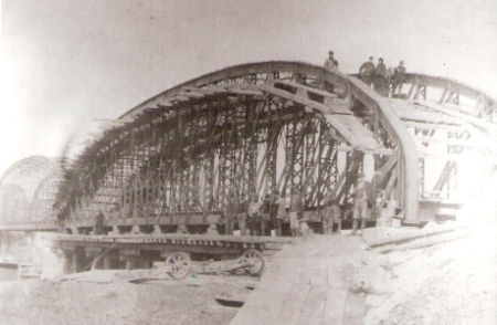  Železničný most cez Váh pri Trenčíne počas stavby železnice Trenčín - Žilina. Poleliptické nosníky, skupina robotníkov, drevené lešenie, fúriky. Anon., 1883. 130 x 90, repro: J. Halaša 