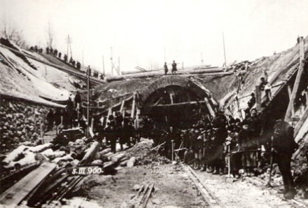  Bratislava hl. st. - tunel počas prestavby. Tunelový otvor bez portálu, zárez, pózujúci ľudia s náradím, vľavo zárubný múr, drevené lešenia. Anon., 5.3.1900. 173 x 122 