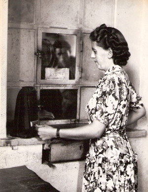  Žena v civile pri okienku na predaj cest. lístkov obsluhuje kompostér novšieho typu. Anon., cca 1955. 113 x 145 