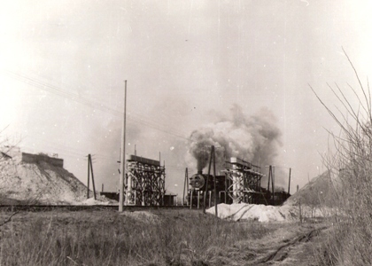  Predelektrifikačné úpravy na trati Brodské - Kúty. Rozostavaný nadjazd nad traťou. Staveniskom prechádza nákl. vlak s rušňom 555.3. Foto: Andraščík, cca 1967, 228 x 167 