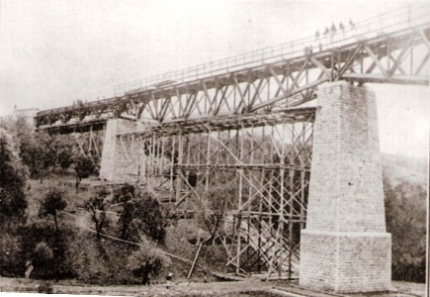  Jedno pole viaduktu počas stavby. Pod ním drevené lešenie. Text: Myjava - montážne lešenie viaduktu, 3. a 4. otvor. Anon., cca 1927. 130 x 90, Repro: R. Rebro 