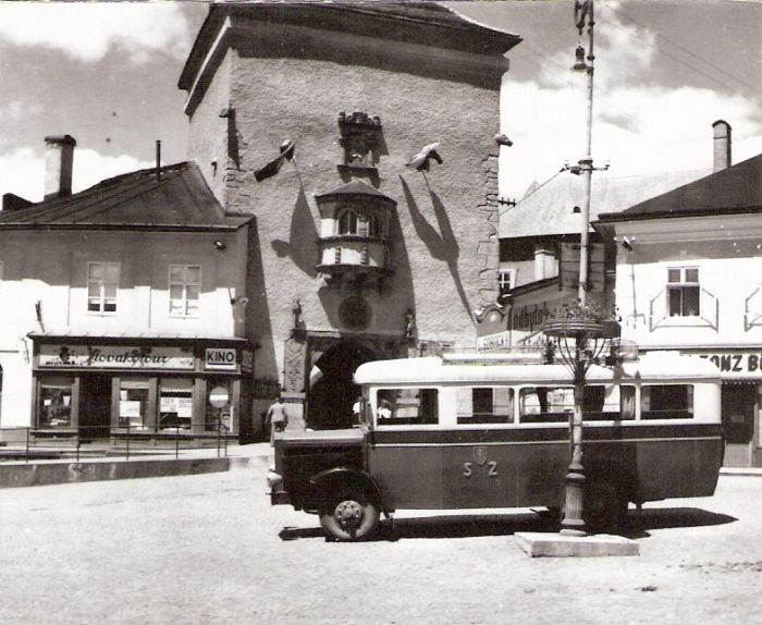  Kremnica, Malé námestie. Autobus (asi Škoda) s nápisom SŽ pred mestskou bránou Barbakon.Pred ním osvetľ. kandeláber. Anon., cca 1943. 100 x 100 