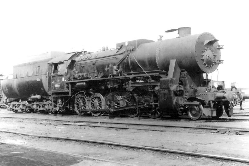  Parný rušeň 555.3253. Pohľad zprava zpredu. Vľavo vzadu časť 475.1. Osvetľ. stĺpy. Anon., cca 1970. 176 x 126 
