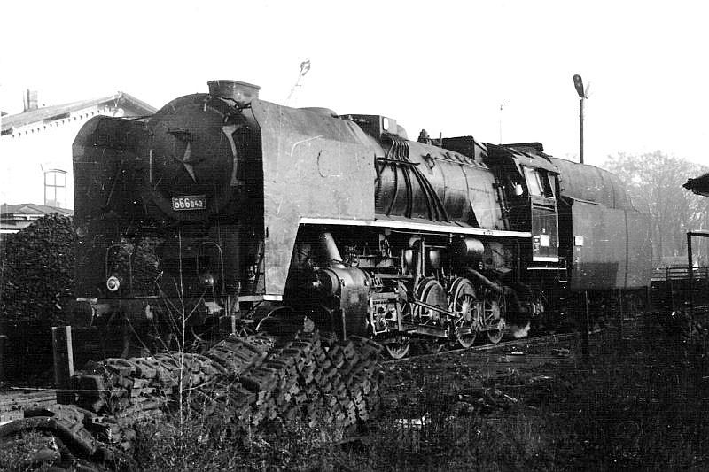  Parný rušeň 556.043 v strojovej stanici Jaroměř. Pohľad zľava zpredu. Vpravo vzadu priečelie adm. budovy depa, vpredu skladka zdrží. Foto: R. Chalupa, 23.11.1979. 147 x 104 