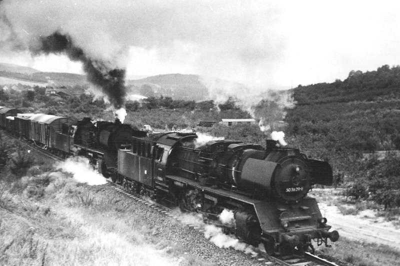  Parné rušne 50 3629-8 a 50 3501 s nákladným vlakom na stúpaní v Gernrode (Harz). Pohľad zprava zpredu. Vzadu kopce. Foto: Anon., 14.8.1983. 122 x 84 
