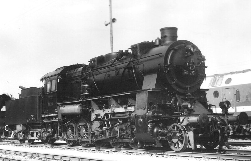  Parný rušeň 58 261 DR v depe Erfurt West. Pohľad zprava zpredu. Vpravo vzadu motorový rušeň DR. Foto: Anon., 6.6.1982. 123 x 84 