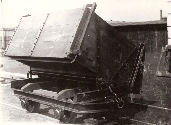  Úzkorozch. nákladný dvojnápravový huntík na prepravu zeminy s drevenou krobou vo vyklopenej polohe vo vagónke Poprad. Pohľad predobočný. Vzadu drevená hala. Foto: Anon., cca 1935. 240 x 178 