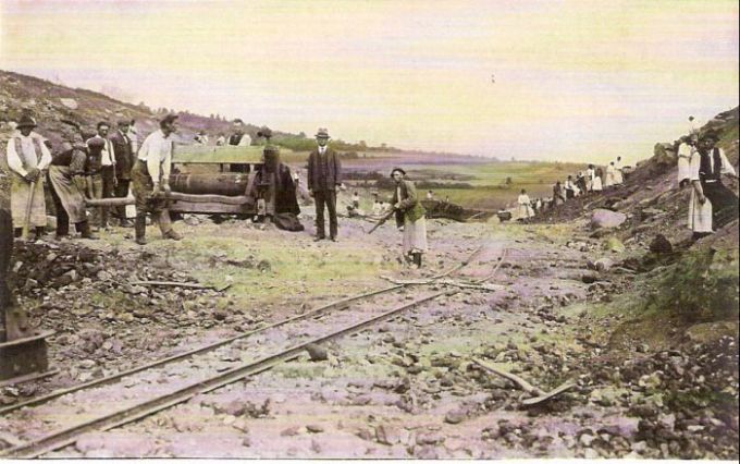 Pohľad z plochého zárezu do krajiny. Ľudia pri odkopávaní svahu a okolo dreveného vrátku. Poľná drážka. Text: Výstavba trate Zvolen - Krupina. Foto: Anon., cca 1923, farebná xerokópia. 145 x 90 