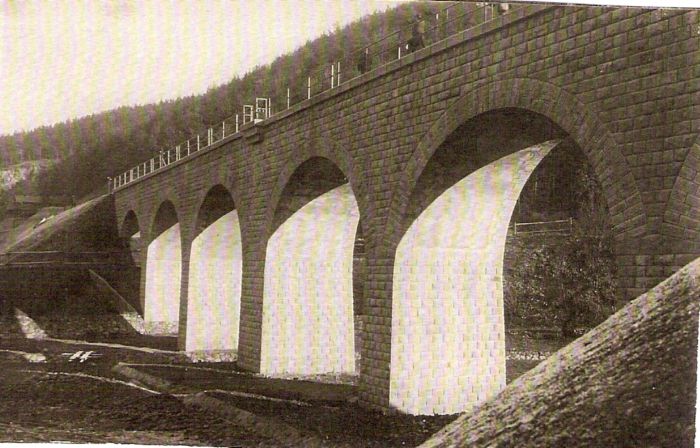  Kamenný železničný most. Pohľad zdola. Vzadu zalesnené úbočie. Vľavo vzadu zrejme strážny dom. Text: Výstavba trate Zvolen - Krupina. Foto: Anon., cca 1923, farebná xerokópia. 138 x 87 