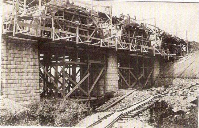  Kamenný most v stavbe. Hotové klenby, ešte s lešením a skružami. Dole stavebná drážka. Text: Výstavba trate Zvolen - Krupina. Foto: Anon., cca 1923, farebná xerokópia. 140 x 90 