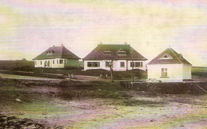  Tri novostavby murovaných obytných domov, pätníky a telegrafná tyč. Text: Výstavba trate Zvolen - Krupina. Foto: Anon., cca 1923, farebná xerokópia. 138 x 88 
