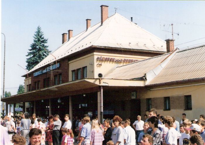  Bánovce nad Bebravou - výpravná budova. Šikmý pohľad zo strany koľají od Topolčian. Zástup ľudí na peróne. Foto: M. Entner, 25.8.1996. 125 x 90, COLOR 
