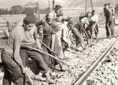  Skupina mužov a žien pri ručnej úprave štrk lôžka v v novej koľaji. Miesto, ako na obr. 7165. Text: Trať Družby. Foto: Kľučka, cca 1950. 117 x 82 