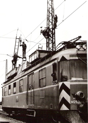  Oprava trakč. vedenia. M 250.0013, robotníci na jeho plošine a na trakč. podperách. Foto: M. Meliška, cca 1980. 122 x 175 