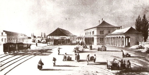  Trnava - výpravná budova, drevená hala s vozňami a ďalšie budovy konskej železnice. Os. vlak, ľudia, povozy, nosítka. Faksimile podľa originálu zo zbierok GMB. 180 x 104 