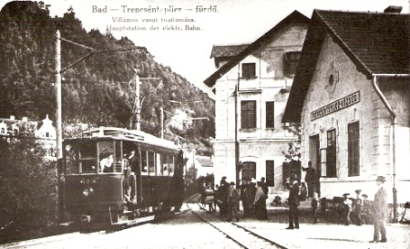  Stanica Trenčianske Teplice - priečelie výpravnej budovy a hotela Garni, motorový vozeň, trakč. podpera, ľudia. Anon., cca 1910, 130 x 83, repro: R. Rebro (Trenč. múzeum) 
