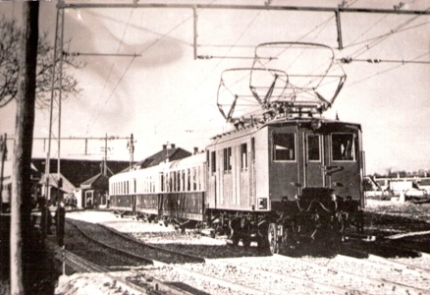  Elektrický rušeň a tri štvorosé vozne železnice Bratislava - Viedeň na zhlaví žst. Fischamend-Markt. Anon, 1914. 182 x 130 