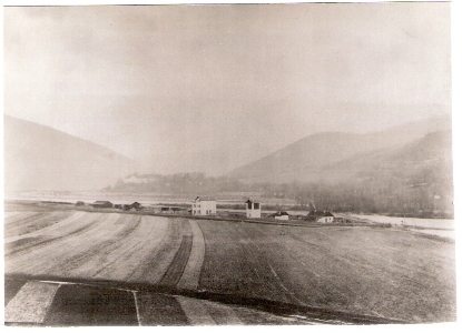  Považská Bystrica - pohľad zdiaľky. Výpravná budova, vodáreň, sklady, ostrov, za Váhom v pozadí kaštieľ. Foto: M. Stern, cca 1885. 128 x 90. Repro: Grófová 