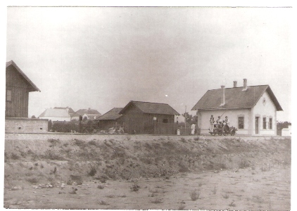  Ozorovce - výpravná budova, búdka toalety, kraj skladu, štvorkolesová drezína, kilometrovník, ľudia v krojoch. Foto: Lieszkovský, 1901. 130 x 90, repro: Grófová 