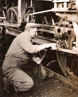  Muž v pracovnom s kladivom pri križiaku parného rušňa, zrejme 475.1. Anon., cca 1955. 84 x 115 