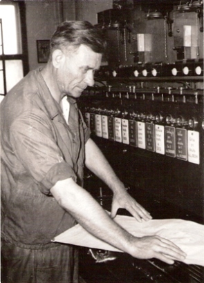  Muž v pracovnom pri riadiacom elektromech. prístroji (zrejme zo žst. Trnava). Text: Ved. BSP Štefan Šverčič, OZ dielne Bratislava. Anon., cca 1960. 130 x 180 