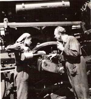  Žena v pracovnom pri mastení ojnice na rušni zrejme 344.4. Muž v pracovnom dozerá. Text: Výhrevňa Zvolen. Foto: Kľučka, cca 1950. 123 x 135 