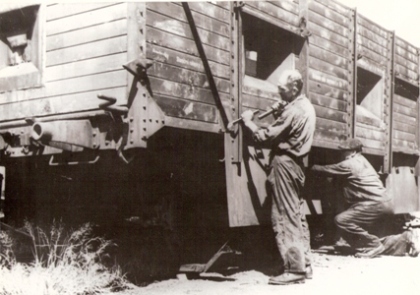  Dvaja muži v pracovnom pracujú na rekonštrukcii guľometného vozňa povst. panc. vlaku. Anon., cca 1953. 227 x 167 