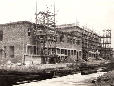  Výpravná budova v Banskej Bystrici počas výstavby. Drevené lešenia, burinou zarastené perónne hrany. Anon., cca 1950. 163 x 123 