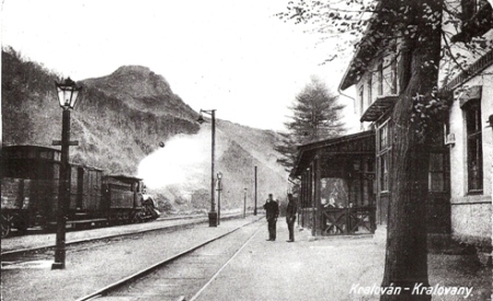  Kraľovany - koľajisko, nákl. vlak s 313.6, vpravo prieč. výpr. budovy s drev. verandou. Petrolej. lampy na drev. stĺpoch. Železničiari, civilisti. Xerox. kópia. Anon., ca 1910. 275 x 175 