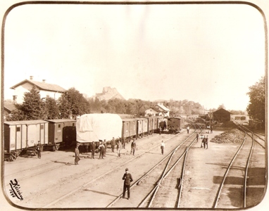  Fiľakovo - Lučenec. Zhl., výhybky s lampami netopier. Dve súpr. nákl. vlak., vľ.za stromami zrejme vodáreň, ďalej obyt. dom. Vpr. drev. sklad a 313.6 pri ošetrení. Hrad, žel., civilisti. Foto: Kóczány, 1896. 225 x 175 