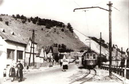  Jednokoľaj. úzkorozchod. elektrifik. trať v obci. Motorový vozeň M 24.0 s prívesom. Text: Električka v Trenčianskej Teplej. Anon., cca 1935. 130 x 90. Repro: R. Rebro 