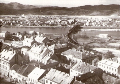  Trenčín - pohľad z hradu na Váh a železničné mosty (ľavý je priamopásový, pravý poloparabolický). Do stanice vchádza nákl. vlak s 556.0. Foto: R. Jelínek, 1960. 130 x 90 