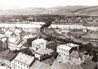  Trenčín - pohľad z hradu na Váh a železničné mosty (ľavý je priamopásový, pravý poloparabolický). Zo stanice odchádza nákl. vlak, pri vchode čaká druhý s 434.1. Foto: Š. Pozdišovský, 1954, 130 x 90 
