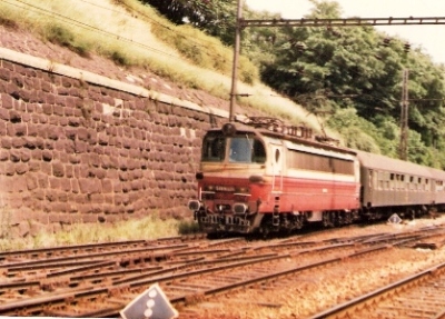  Elektrický rušeň S 489.0 s osobným vlakom odchádza smerom na Lamač v Bratislave hl. st. na lamačskom zhlaví. Vzadu zárubný múr. Foto: Z. Piešová, 1985. 104 x 72, COLOR 