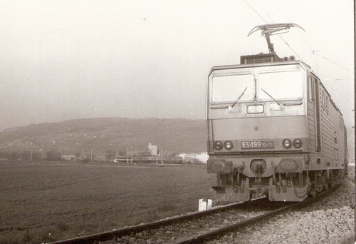  Elektrický rušeň ES 499.1042 na čachtickej spojke pri N. Meste n. V. Vzadu motorový vlak M 286.? + 3 Balm smerujúci do Čachtíc. Foto: Z. Piešová, cca 1985. 150 x 105 