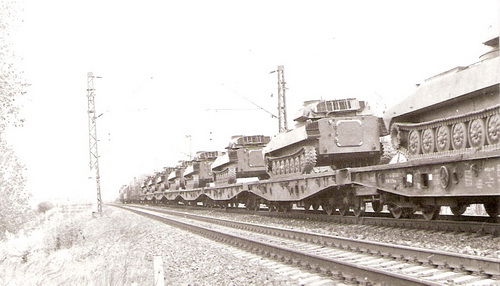  Voj. transport (tanky na štvor- a šesťnápr. ploš. vozňoch) po prech. zast. Bratisl. Vinohrady v smere na Vajnory. Vrchol vodárne Dynamitky. Foto: Z. Piešová, 1989. 130 x 90 