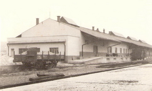 Banská Bystrica (?) - stan. sklad, neupravené okolie, pred ním tri koľaje (jedna v stavbe) s nískost. dvojnápr. vozňom, vzadu Z, vpredu dláždená plocha perónu. Anon., cca 1950 128 x 82 