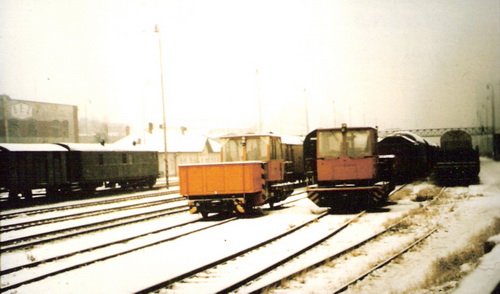 Bratislava filiálka - zimný pohľad na výpravnú budovu od Domu odborov. Odst. nákl. vozne, prac. vozne a mechaniz. Vzadu lávka a BEZ. Foto: M. Entner, zima 1988. 147 x 110, COLOR 