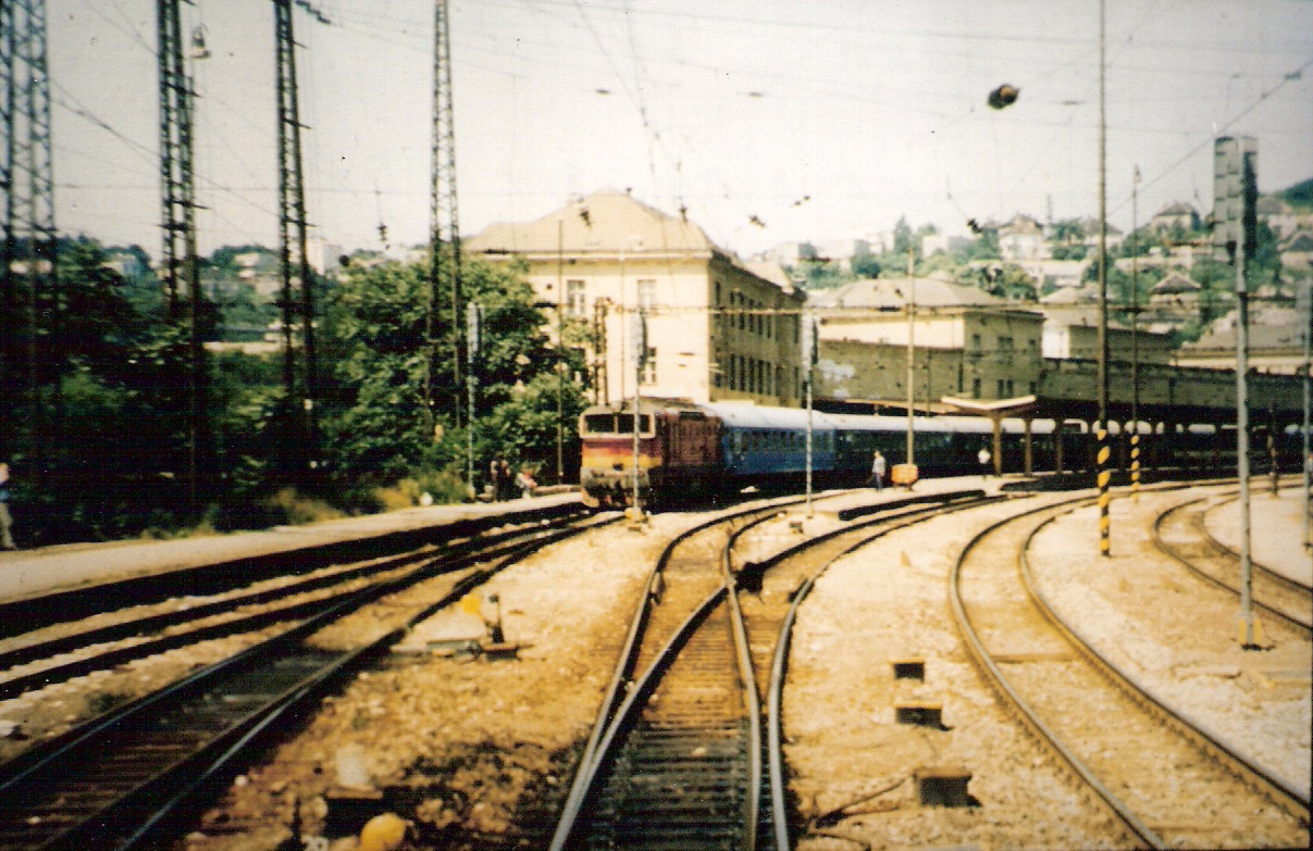  Bratislava hl. st. - pohľad zo stred. dverí posled. vozňa na koľajisko stanice. Pri 1. peróne rýchlik s 754. Výpr. budova, nástupištia. Foto: M. Entner, 8.1989. 158 x 100, COLOR 