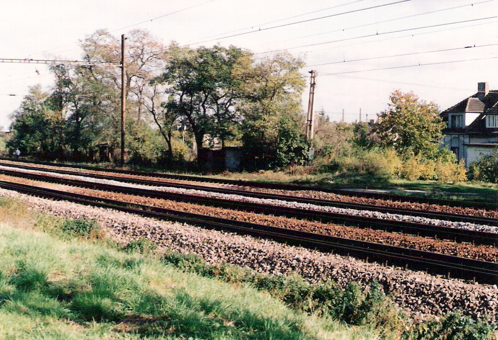  Trať Bratislava hl. st. - Ba-Vinohrady. Štvorkoľajná elektrifik. trať, za ňou obyt. dom. Text: Bratislava - Biely kríž, staré priecestie. Foto: M. Entner, 20.10.1996. 125 x 90, COLOR 