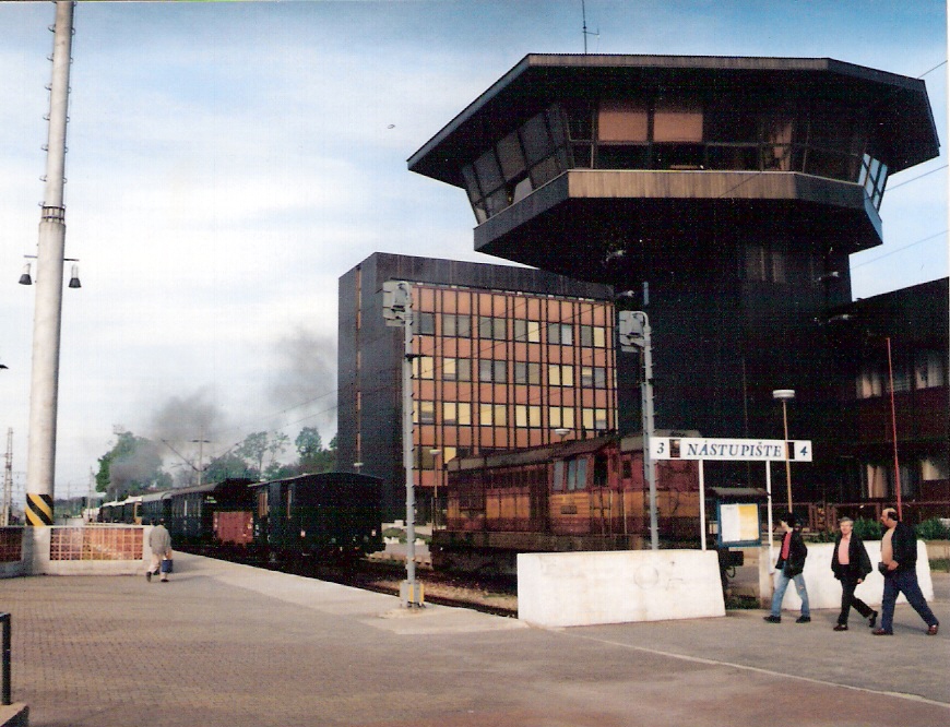  Trnava - administratívna budova a dopr. kanelária novej stanice, 3. nástupište, pri ňom parný vlak s 331.037, v tupíku T 466.2. Anon., 5.1997. 126 x 88, COLOR 