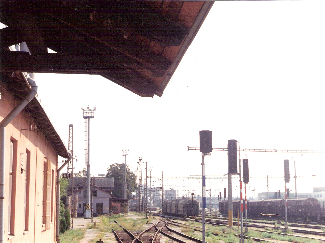  Trnava - pohľad od starej výpr. budovy k novej stanici. Zriaď. a cest. návestidlá, odst. nákl. vozne, odchádz. poschod. os. súprava. Foto: M. Entner, 1994. 177 x 125, COLOR 