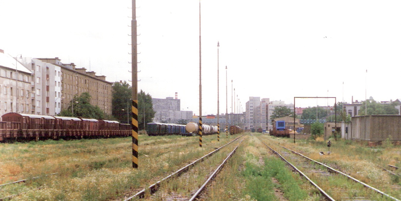  Bratislava filiálka - pohľ. z úrovne polikliniky na Tehelnej ul. v osi koľají smerom na žel. polikl. Odstavené nákl. vozne, vpravo obrysnica a váha, vľavo domy na Kukuč. ul. Foto: M. Entner, leto 1994. 177 x 125, COLOR 