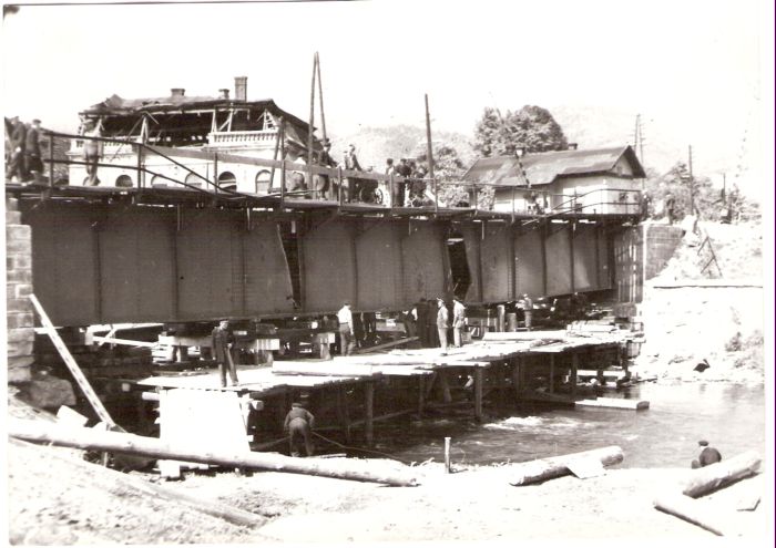  Vrútky - poškod. plech. most nad Turcom, podoprený drevenou proviz. konštrukciou. Vzadu strážny dom so zvonk. náv. a dvojdrôt. závorami. Ľudia pri práci, na moste triodyn. Anon, 3.5.1945. 182 x 130 