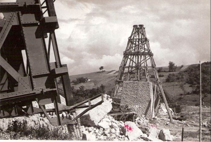  Hanušovce - trosky žel. mosta v pahork. krajine - lichobežn. most. polia v na zemi, rozváľ. kamen. piliere, jeden v stavbe s lešením. Vľ. detail konštr. poľa. Text: Hanušovce - znič. most. Foto: ČSD, cca 1945. 171 x 115 