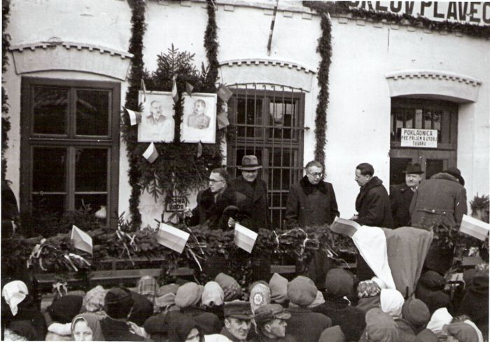  Orlov-skup. činovníkov na ozdob. tribúne pred výpr. bud. s pôv. fasád. výzdob. a nápisom ORLOV PLAVEČ. Obr. Beneša a Stalina. Sledujúci ľudia. Text: Znovuotv. trate Orlov - Plaveč po 2. sv. vojne. Anon., cca 1945. 168 x 118 