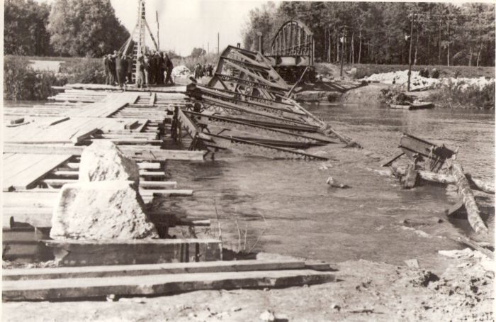  Trať Hodonín - Holíč. Trosky poloparabol. mosta v km 3,009, strhnutá konštr. stred. poľa v rieke, zdvih. konštruk. kraj. poľa smer Hodonín. Lávka, baranidlo pri práci, telegr. tyče, vz. les Anon., cca 1945. 226 x 148. 