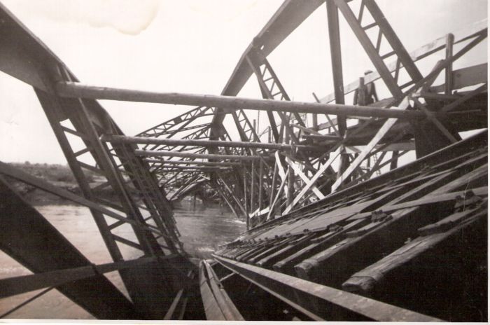  Trať Leopoldov - Hlohovec. Trosky poloparabolic. mosta cez Váh. Pohľad v osi koľaje. V moste lávka pre peších. Rieka. Text: Most v Hlohovci. Foto: Morávka, cca 1945. 175 x 116 