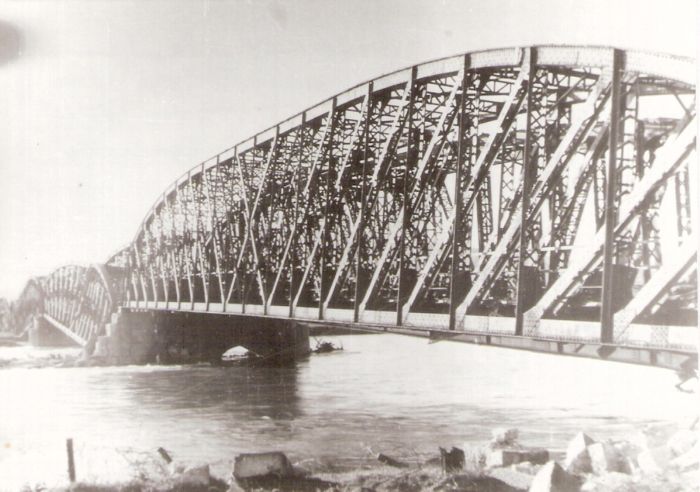  Trenčín. Zničený elipt. železn. most cez Váh. Pohľad zboku pozdĺž mosta. Rieka. Text: Vojnou zničený železn. most. Anon., cca 1945. 130 x 90, Repro : Š. Pozdišovský 